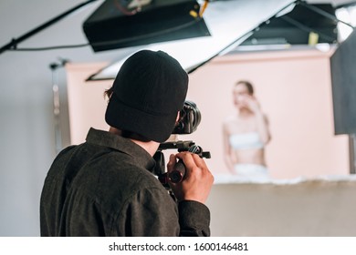 Back View Of Cameraman Working With Female Model In Photo Studio