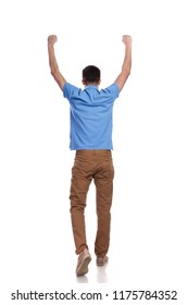 Back View Of A Casual Man Walking With Hands In The Air Celebrating Success On White Background