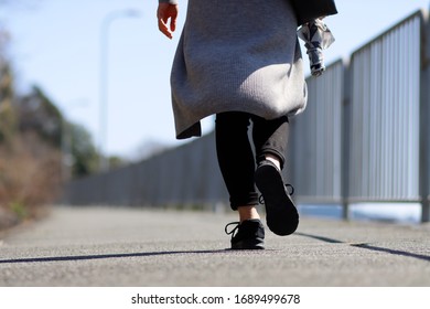 Back view of casual style walking woman