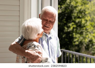 Back view of caucasian senior couple embracing and looking at each other on balcony on sunny day. Retirement, togetherness, wellbeing, domestic life and senior lifestyle, unaltered. - Powered by Shutterstock