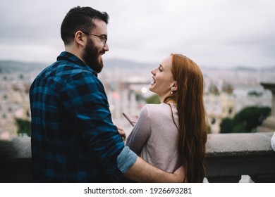 Back view of cheerful male and female tourists discussing conversation and laughing during leisure time, happy Caucasian couple in love enjoying live talking during getaway travelling on vacations