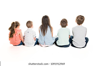 Back view of child group sitting on floor looking at wall