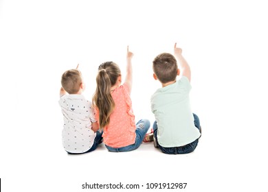 Back View Of Child Group Sitting On Floor Looking At Wall