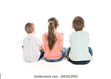 Back View Of Child Group Sitting On Floor Looking At Wall