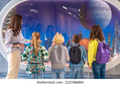 Back View Of Children And Teacher Looking At Screen