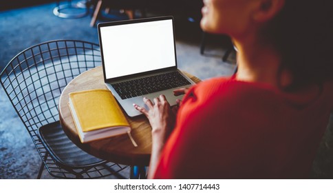 Back View Of Chinese Hipster Student Keyboarding On Modern Laptop Using Wireless Internet Connection For Remote Work.Digital Netbook With Blank Screen Area For Your Advertising Text Or Content