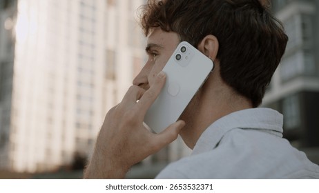 Back view close up head unrecognizable unknown man talking mobile phone cellphone answering call communication conversation discuss male guy student businessman business entrepreneur city outdoor town