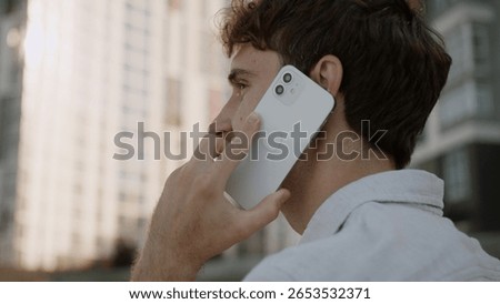 Back view close up head unrecognizable unknown man talking mobile phone cellphone answering call communication conversation discuss male guy student businessman business entrepreneur city outdoor town