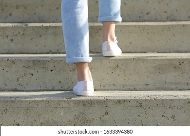 Back View Close Up Of A Woman Legs Wearing Sneakers Walking Up Stairs