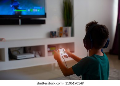 Back view of concentrated young gamer playing game. gaming game play tv fun gamer gamepad guy controller video console playing player holding hobby playful enjoyment view concept.