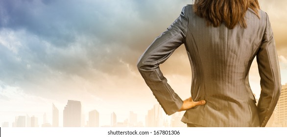 Back view of confident businesswoman with arm on waist