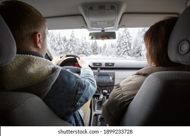 Back View Of Couple Enjoying Car Ride In Winter Forest