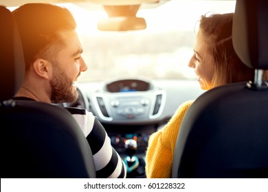 Back View Of Couple Enjoying Car Ride, Smiling Cheerfully. Looking At Each Other. Car Ride.