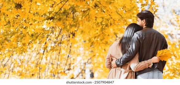 Back view of couple hugging and walking together by autumn forest, panorama with empty space - Powered by Shutterstock