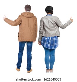 Back view of couple couple in winter jackets showing thumbs up. beautiful friendly girl and guy together. Rear view people collection. backside view of person. Isolated over white background.