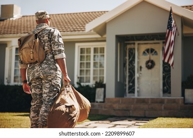 Back view of a courageous young soldier walking towards his house with his luggage. American serviceman coming back home after serving his country in the military. - Powered by Shutterstock