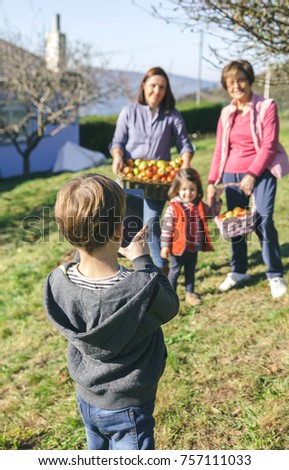 Similar – Image, Stock Photo Boy taking photo to family with apples in basket