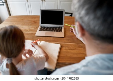 Back View Of Dad And Teen Girl Child Study Online On Computer Do Homework Together On Internet At Home. Father Help Small Daughter With School Task Assignment On Laptop. Distant Education Concept.