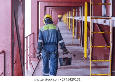 Back view of a deck crew member performing routine duties on the open deck during a sea voyage.