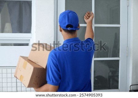 Back View of Delivery Man Knocking on The Client's Door
