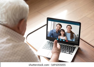 Back View Of Elderly Grandfather Talk Chat On Video Call On Computer With Family And Granddaughter, Mature Granddad Have Online Conversation Using Webcam On Laptop With Happy Relatives