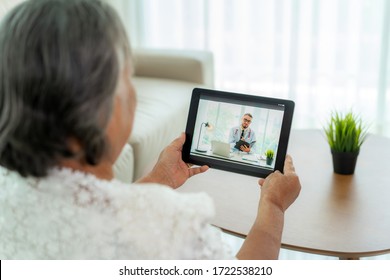 Back View Of Elderly Woman Making Video Call With Her Doctor With Her Feeling Sick On Digital Tablet Online Healthcare Digital Technology Service Consultation While Staying At Home. 