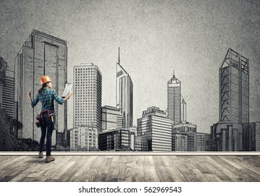 Back View Of Engineer Woman With Folder And Sketches Of Construction Project On Wall