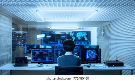 Back View Of The IT Engineer Working With Multiple Monitors Showing Graphics, Functional Neural Network. He Works In A Technologically Advanced System Control Data Center.