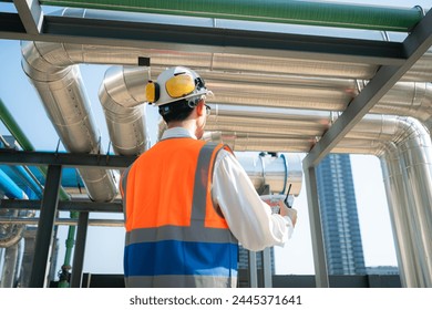 Back view of Engineers inspect the completed air conditioning and water systems to continue verifying their functionality.