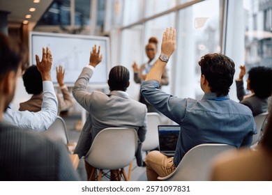 Back view of entrepreneurs asking questions from the audience while attending a business conference in board room.