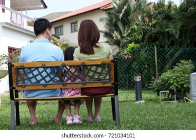 Back View Of Family Sitting On The Bench