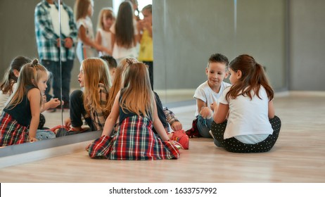 Back view of fashionable kids talking with each other while sitting on the floor and having a break in the dance studio. Choreography class. Hobby. Dance school - Shutterstock ID 1633757992