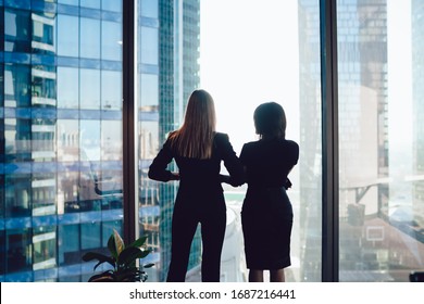 Back View Of Female Colleagues In Formal Wear Standing Near Window Looking At Modern Exterior Of Skyscrapers In Business Center, Prosperous Women Standing Together Planning Prosperous Future Success