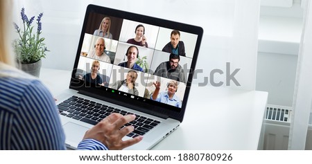 Back view of female employee speak talk on video call with diverse multiracial colleagues on online briefing, woman worker have Webcam group conference with coworkers on modern laptop at home