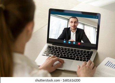 Back view of female employee talk with male businessman on webcam laptop conference, woman worker negotiate with man employer brainstorm on video call from home, online consultation concept