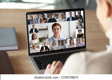 Back View Of Female Employee Talk On Video Call On Laptop With Diverse Colleagues, Have Group Web Conference Or Meeting, Woman Worker Engaged In Webcam Conversation With Coworkers From Home