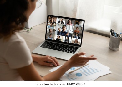 Back View Of Female Employee Talk Speak On Team Video Call With Diverse Colleagues Coworkers. Woman Worker Have Webcam Digital Virtual Conference At Home Office, Engaged In Online Group Meeting.