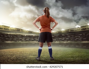 Back view of female football player standing on the field