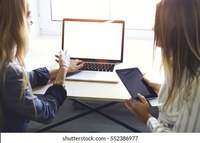 Back View Of Female Freelancers Colleagues Trying To Connect Gadget And Modern Laptop Computer With Mock Up Display While Sharing Multimedia Files And Checking Email Box Using Wireless Internet 