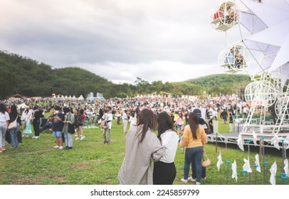Back view of female friends watching concert in the park at open air, in front of stage. - Shutterstock ID 2245859799