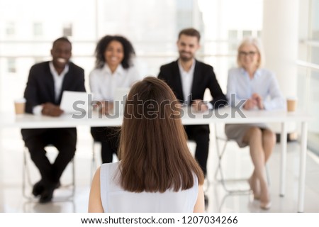 Back view of female job applicant make good first impression at work interview in office, millennial woman candidate talk, impress HR managers or recruiters at hiring. Employment concept