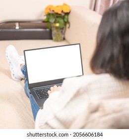 Back View Of Female Lying On Couch Texting On Laptop. Woman On Sofa Working On Laptop With Mockup Blank Screen. Empty Copyspace. Square Image