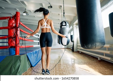 Back view of fitness woman skipping rope in gym. Cardio and fitness workout. Sport concept            - Powered by Shutterstock