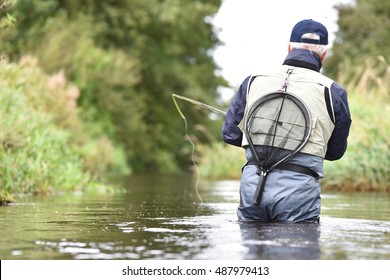 Back view of fly-fisherman fishing in river