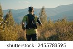 Back view focused Caucasian male man person runner guy mountaineer sportsman running jogging trail outside countryside meadow mountain hill sunshine. Sport motivation healthy lifestyle workout fitness