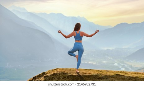 Back view of free calm serene blissful satisfied fitness woman doing yoga exercise on top rock against idyllic morning mountain view. Mental mind care and healthy habits - Shutterstock ID 2146982731