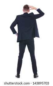 Back View Full Length Picture Of A Young Business Man Standing With A Hand On His Hip And Scratching His Head With The Other. On White Background