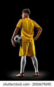 Back View Full-length Portrait Of Young Handsome Football Player In Yellow Uniform Isolated Over Black Background. Concept Of Action, Team Sport Game, Energy, Vitality. Copy Space For Ad.