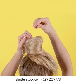 Back view of a girl doing a bun hairstyle. - Powered by Shutterstock