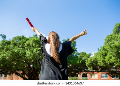 back view of girl gratuate happily at campus with diploma holding in her hand